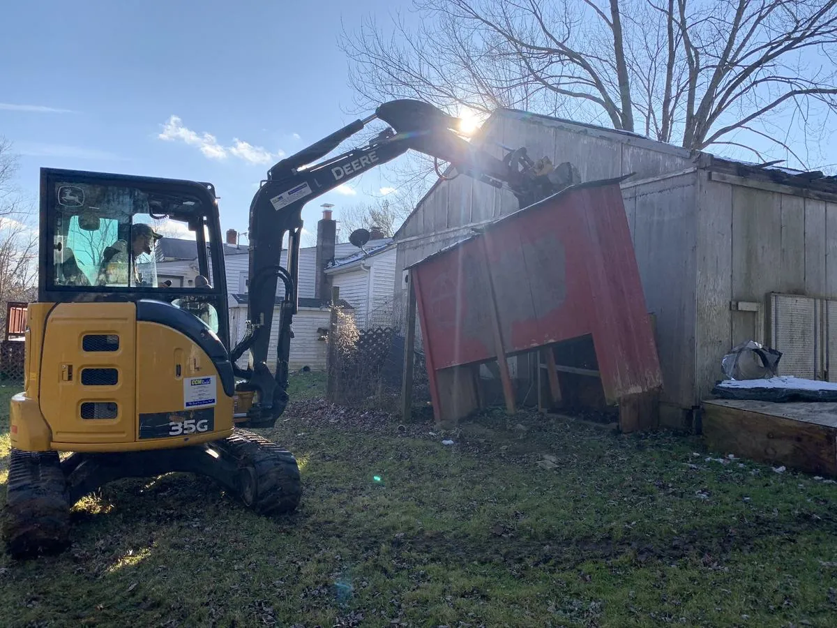 Mini excavator pulling down a backyard shed by Monthly Upkeep in the Cleveland area