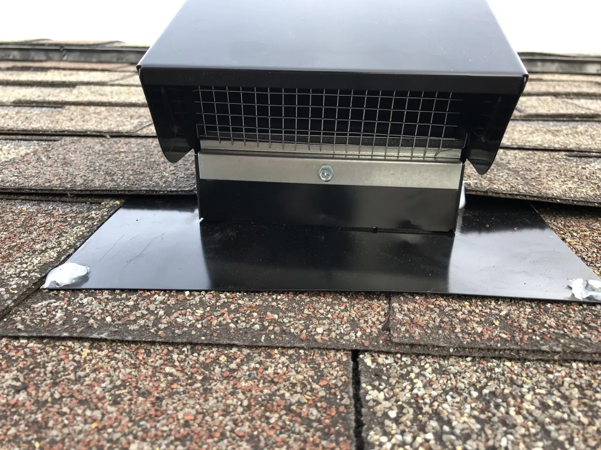 Black metal roof vent cap with mesh screen installed on an asphalt shingle roof by Monthly Upkeep in the Cleveland area