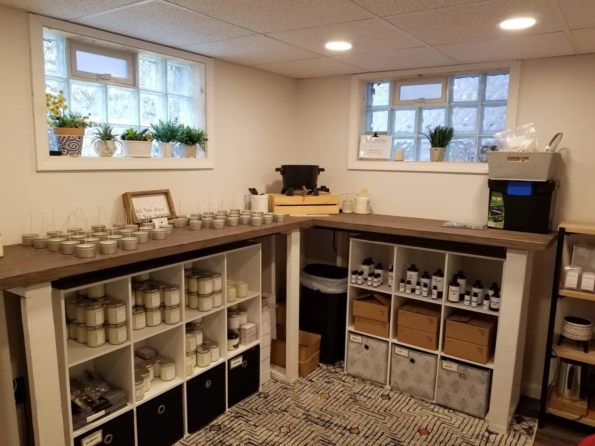 Room with glass block windows, wood-top counters, and shelves holding candles and bottled products